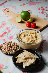 Homemade chickpea hummus bowl with pita chips and paprika