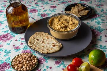 plate with hummus alongside flatbread and lemons, Ramadan food