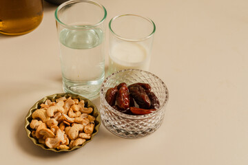 dates, nuts, and chestnuts alongside a glass of water and yogurt