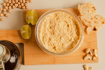 plate of hummus next to a bottle of olive oil, slice of lemon