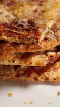 Delicious stacked gluten free pizza or flatbread rotating slowly on a plate,  close up. Homemade gluten free food, meal prep. Cooking at home