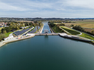 Aerial view of a hydroelectric plant with solar panels, showcasing modern clean energy production for climate action. © 24K-Production