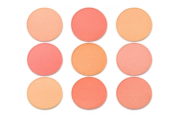Nine round makeup blush pans showing a range of coral, peach, and pink powder shades for cosmetic beauty on transparent background
