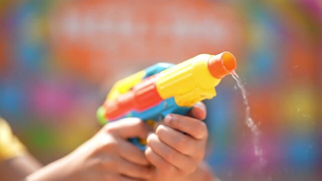 holi  colour holiday  2026 a person holding colorful water gun on celebration with festival and fun and play and joy and toy and weapon and watergun and splash and rainbow with blur holiday  2026