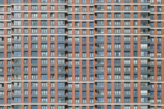 Modern architectural facade with symmetrical window placements. Big myltistorey residential house. - Powered by Adobe