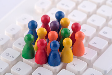 Colorful group of pawn people figures on computer keyboard