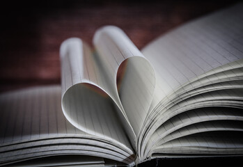 Open note book with two heart shaped pages isolated with copy space