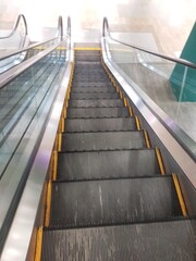 Downward Escalator View with Metallic Rails and Yellow Accents