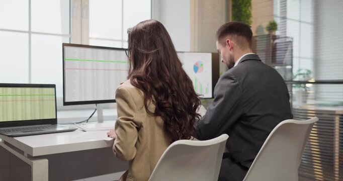Coworkers analyzing data on computer monitors. Analysts review a finance report in office as a team, collaborating on spreadsheets, budgeting, and forecasts. Business team concept in office.