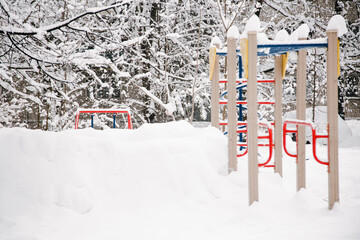 An empty and snow-covered childrens playground in the early December morning