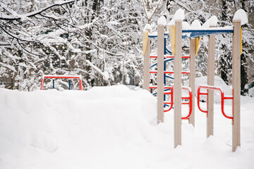 An empty and snow-covered childrens playground in the early December morning
