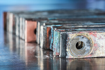 Patinated copper busbars showing the structure of oxidation, aging, and electrochemical corrosion on the metal surface in the power industry.