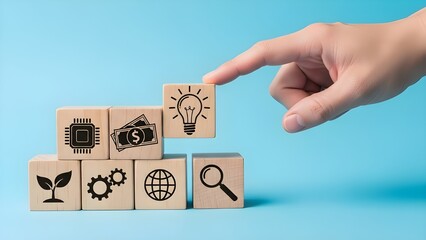 Hand pointing to lightbulb symbol on wooden blocks displaying various icons