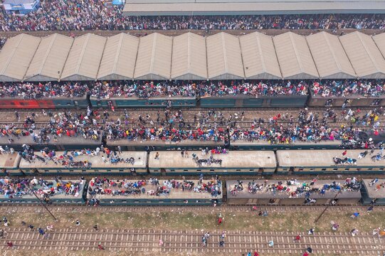 Tongi, Bangladesh - 12 January 2020: Aerial view of a sea of people atop trains at Tongi Rail Station, a chaotic scene of vibrant colors and textures..