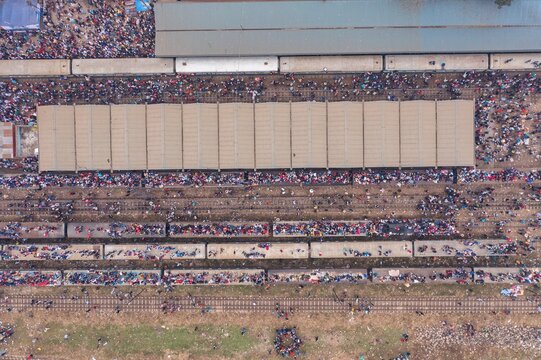 Tongi, Bangladesh - 12 January 2020: Aerial view of the Tongi Rail Station Road, where a multitude of people gather amidst the trains and tracks, creating a vibrant scene.