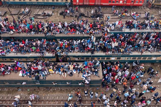 Tongi, Bangladesh - 12 January 2020: Aerial view of a sea of people atop crowded trains at Tongi Rail Station Road, a vibrant tapestry of color and chaos.