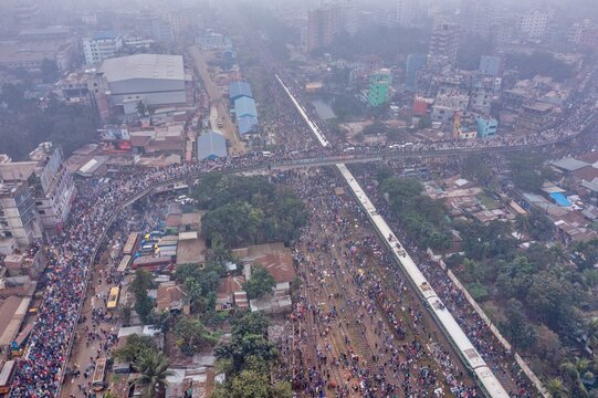 Tongi, Bangladesh - 12 January 2020: Aerial view of a bustling street scene near Tongi Rail Station Road, where crowds throng between buildings and along railway tracks.