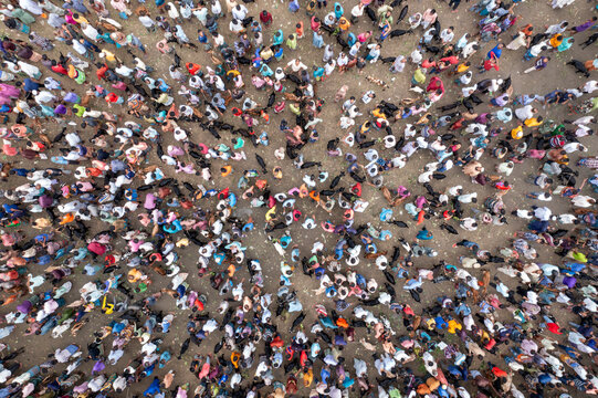 Bogura, Bangladesh - 31 July 2020: Aerial view of a densely packed crowd, a sea of humanity where individual colors and patterns blend into a vibrant mosaic.