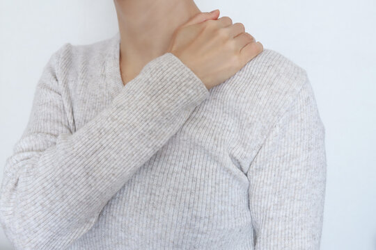 肩を押さえる女性の後ろ姿