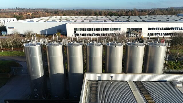 Milton Keynes, United Kingdom - 20 December 2025: Aerial view of gleaming silver tanks standing in contrast to the muted tones of surrounding buildings and winter trees.