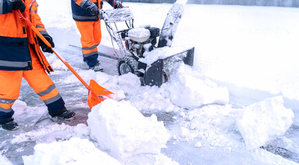 A janitor removes snow after a snowfall on the street with a snow blower