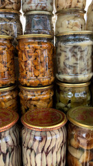 Different types of canned mushrooms in jars on a shelf. Forest, wild mushrooms in the diet.