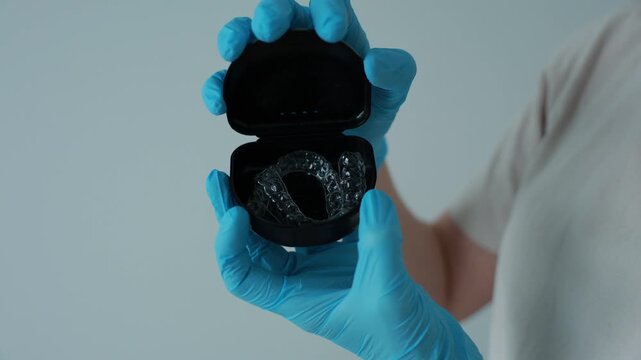Dental professional opening a case with clear aligners. Orthodontic treatment and modern dental care concept.