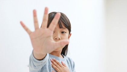 手を広げてカメラに向けて拒否を示す子供、室内の自然光とコピースペースのある高解像度イメージ
Child showing refusal with open hand toward camera, indoor natural light scene with copy space, high‑resolution image
