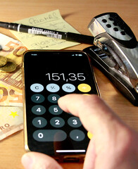 Contando dinero y sumando con app calculadora de tel&eacute;fono m&oacute;vil
