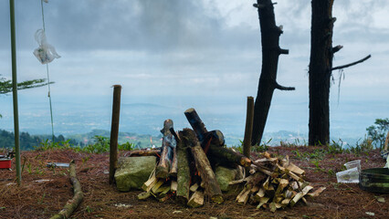 Outdoor Campfire Wood Pile On Hilltop Overlook With Misty Valley And Distant Mountains