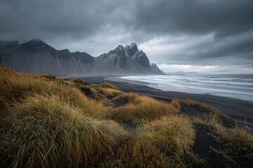 Dramatic black sand beach meets rugged mountains under a stormy sky