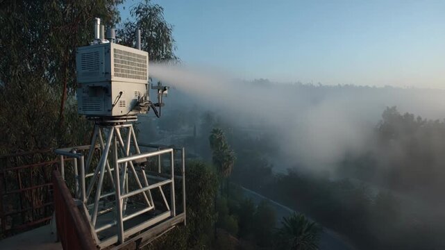 View of a largescale misting device operating at a landfill dispersing odor neutralizers to maintain a fresh environment in open air.