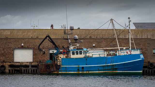 Blue fishing boat docked at MacDuff harbor, Scotland