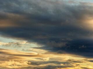 Obraz premium Dramatic dark clouds moving across a golden sky