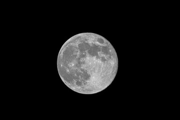 Obraz premium Bright full moon isolated on black night sky with copy space