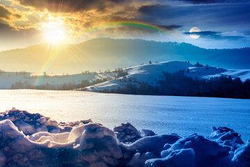beautiful winter landscape with snow covered rolling hills. day and night time change concept. majestic mountains with sun and moon. frosty countryside scenery. harmony and progress calendar