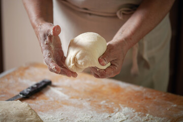 Women's hands make pasty dough