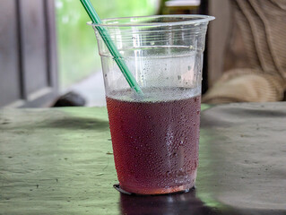 iced tea with dew on the outside of a clear plastic cup