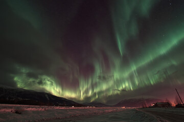 Northern Lights Illuminating Snow-Covered Landscape at Night