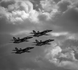 Naval Airshow, F-18 Super Hornet jets flying in formation on beautiful summer day high in the clouds