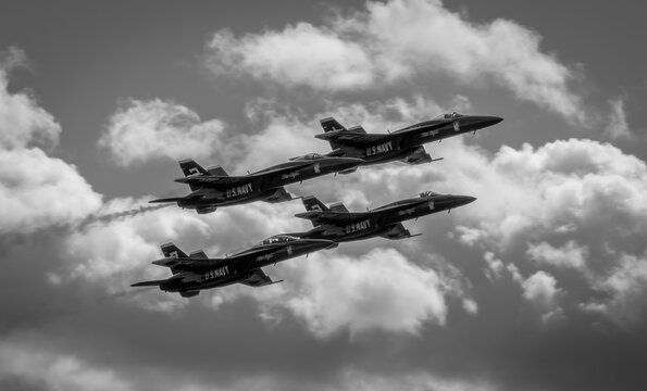 Naval Airshow, F-18 Super Hornet jets flying in formation on beautiful summer day high in the clouds - Powered by Adobe