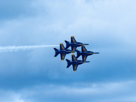 Naval Airshow, F-18 Super Hornet jets flying in formation on beautiful summer day high in the clouds - Powered by Adobe