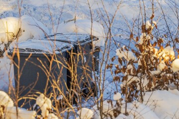 Close up view of recycling bins in residential neighborhood covered with snow during winter. Sweden.
