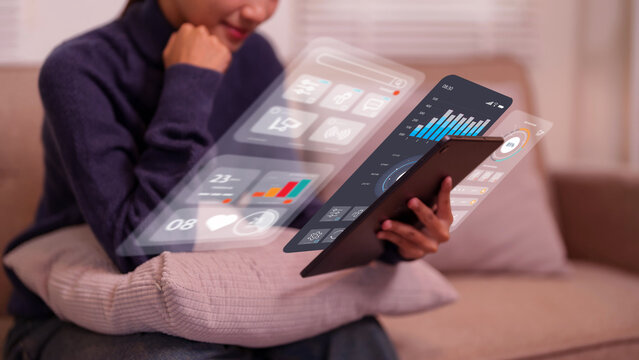 Woman using tablet with futuristic holographic UI for data analysis business intelligence viewing financial charts graphs technology data analytics innovation