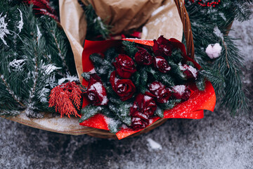 Winter bouquet pine red roses snow outdoor seasonal background.