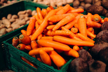 Fresh cleaned carrots box supermarket top view close-up.