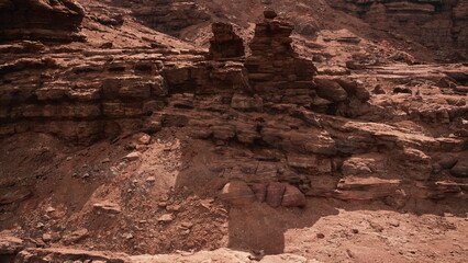 Sunlight casts shadows over ancient rock formations, revealing the raw beauty of a desert landscape. Layers of earth tell stories of time in this stunning natural wonder, inviting adventure.