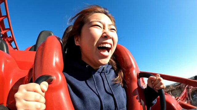 Excited Asian Woman Screaming on a Thrilling Roller Coaster Ride.