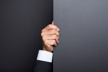 Hand holding a gray board against a dark background in a simple setting with no distractions or details