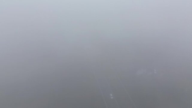 Moody aerial scene of vehicle in foggy neighborhood
